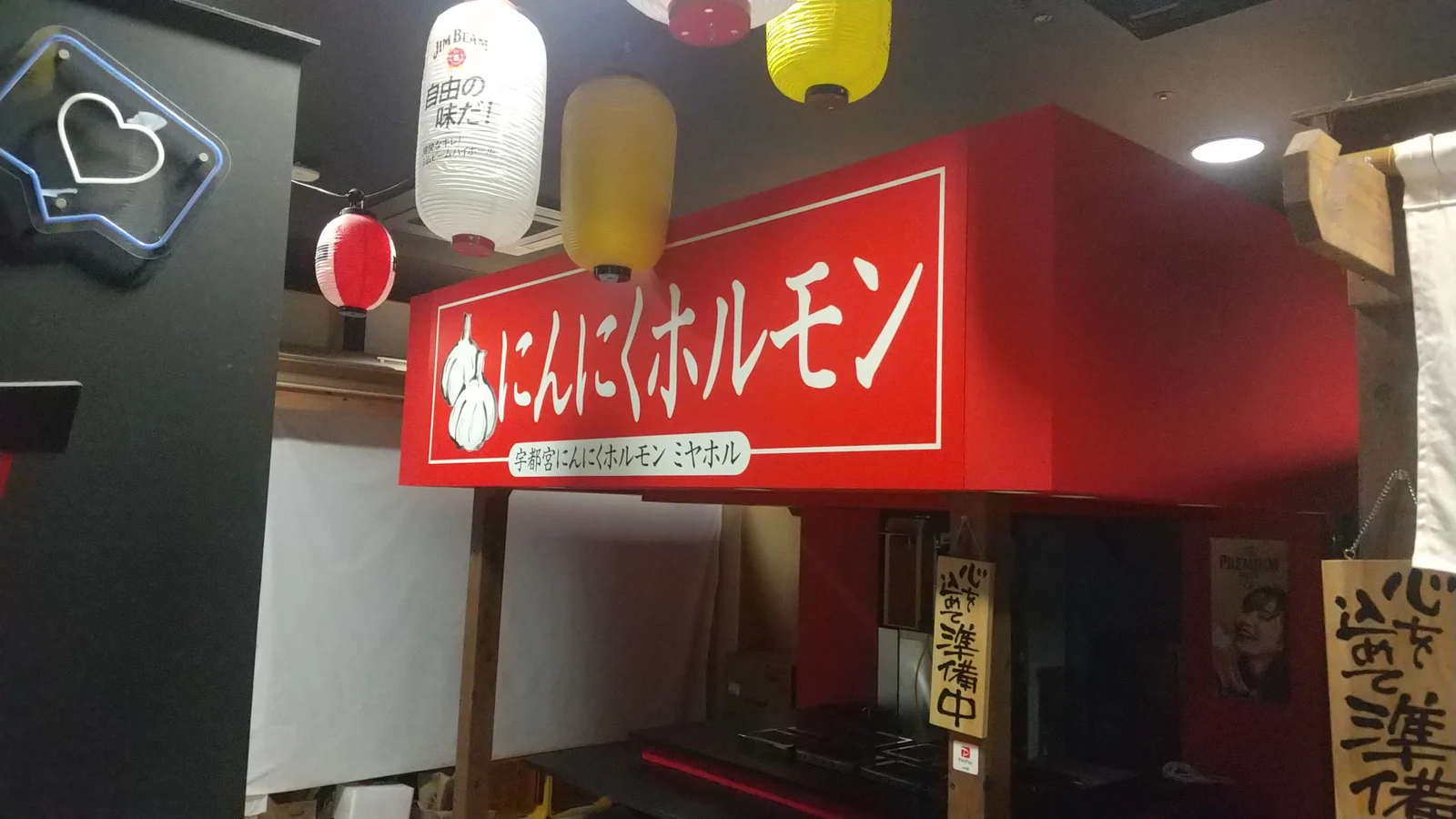 飲食店入口に取り付けた赤いプレート看板の施工写真